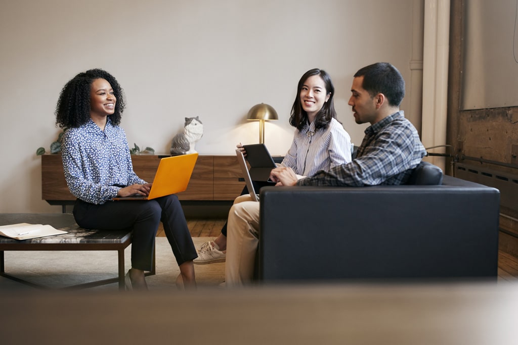 Three young professionals sitting together with their laptops