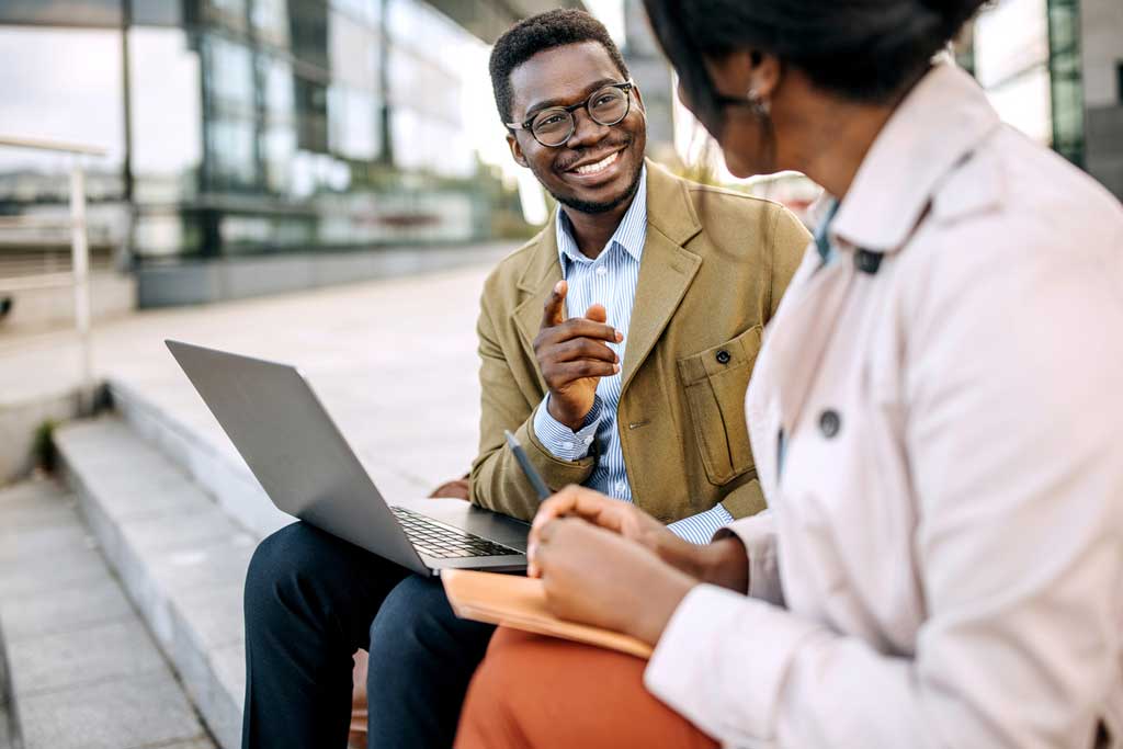 Professional African man chatting with colleague and collaborating